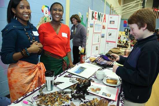Monicah Kivaa (left) and Ann Kivaa teach about their homeland of Kenya as Jamie Aciukewicz examines a hand-carved lion.